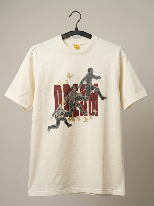White t-shirt with graphic design of people playing instruments and the word 'DREAM' on a beige background